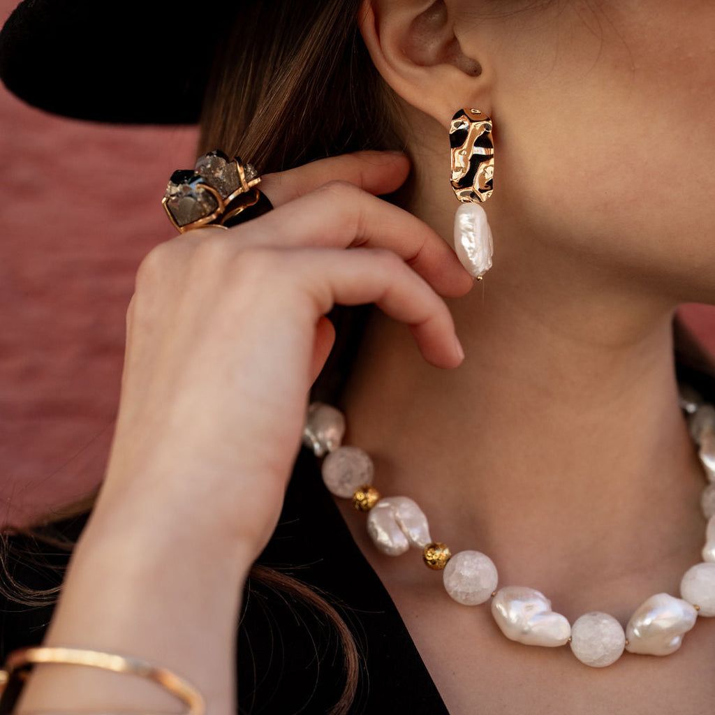 Model trägt süßwasserperlen collier mit bergkristallen und dazu die passenden ohrringe in gold 
